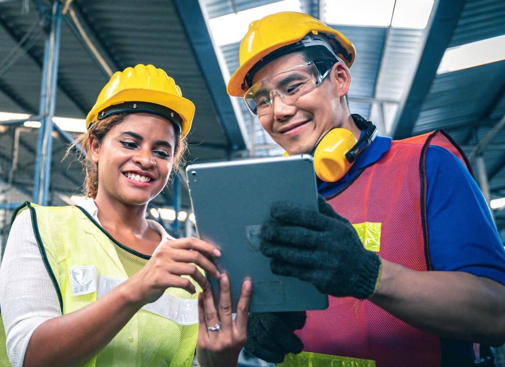 Industrial workers looking at tablet in the warehouse.