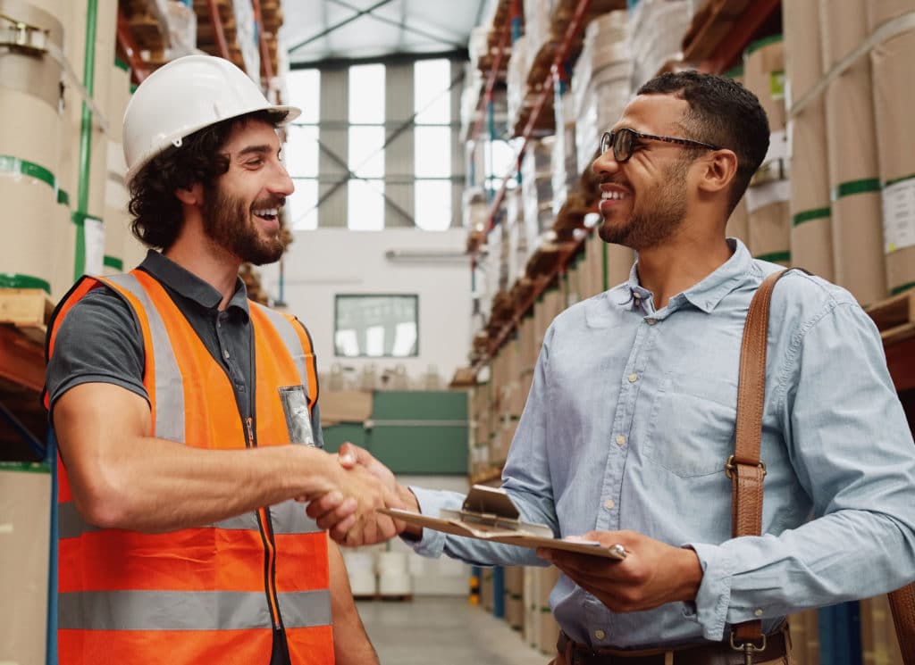 Worker shaking hand of factory manager